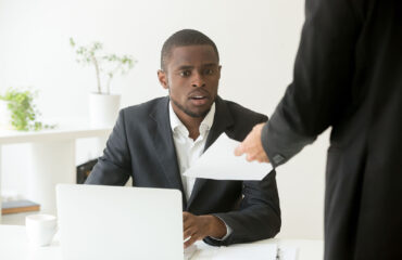 Surprised shocked african businessman getting unexpected notice