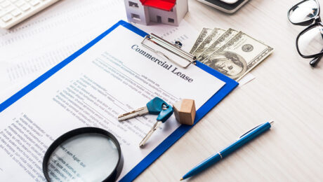 document with commercial lease lettering on clipboard near keys,
